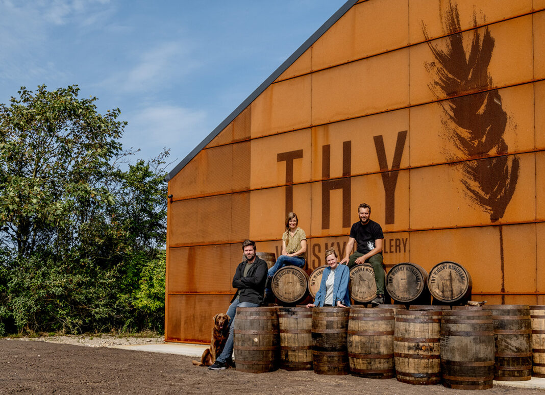 Delar av teamet framför lagerhuset där whiskyn mognar i det danska kustklimatet.